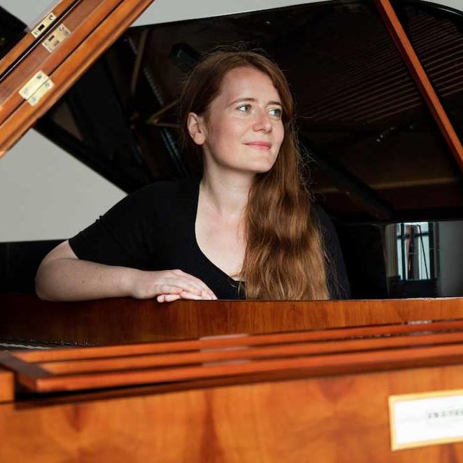 		Person posing at a piano
	