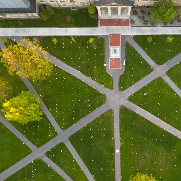 		Green lawn intersected by gray paths, seen from the air
	