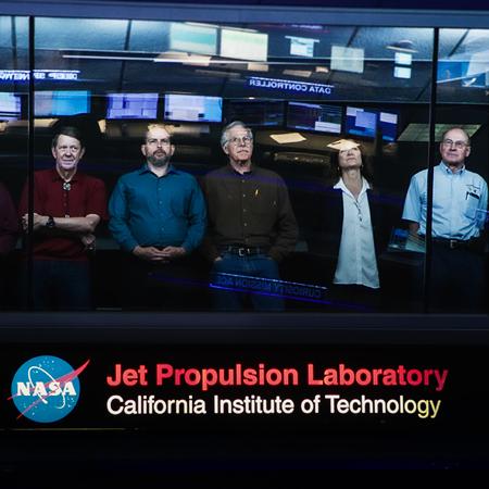 		Cassini team leaders standing at a window, looking up.
	