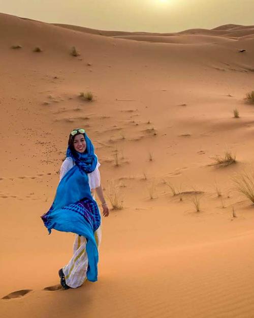 		person wearing blue scarf in a desert
	