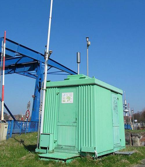 		 An air pollution measuring station, with a long pole rising above it to test the air.
	