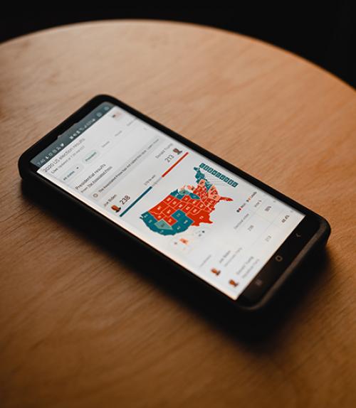 		 phone on table showing a colored map
	