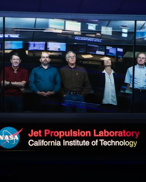 		Cassini team leaders standing at a window, looking up.
	