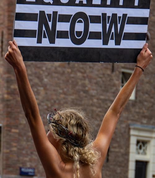 		 Person holding sign, seen from the back
	