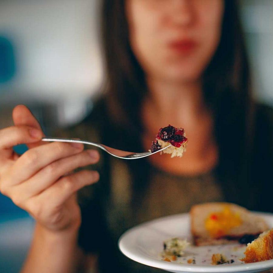 		hand holding fork with food on it
	