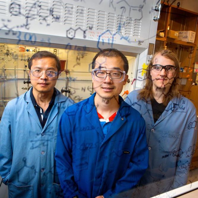 		Three people wearing lab coats and protective glasses
	