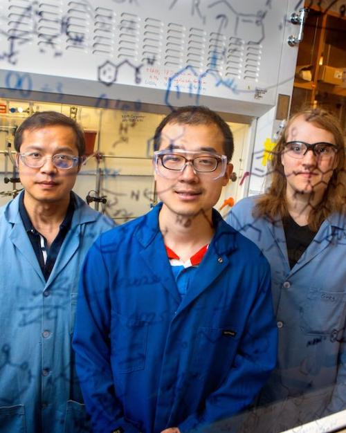 		Three people wearing lab coats and protective glasses
	