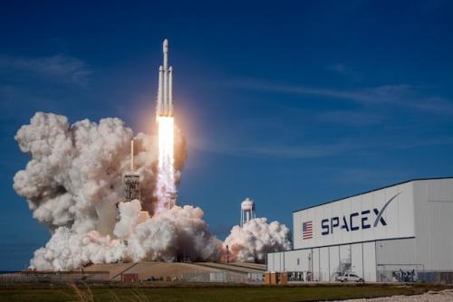 		Rocket blasting off from SpaceX, blazing fire and huge clouds of smoke behind.
	