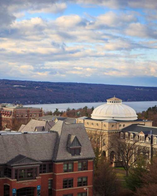 		College campus overlooking a lake under a cloudy sky
	