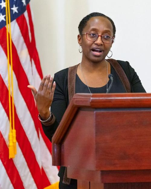 		Person speaking at a podium; American flag in the background
	