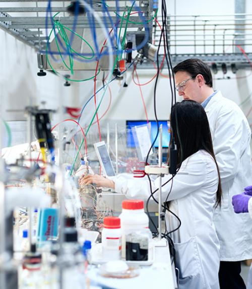 		 Two people in white coats in a laboratory
	