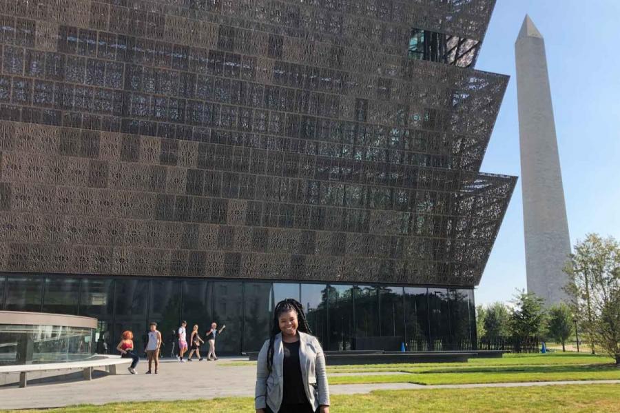 student in front of building