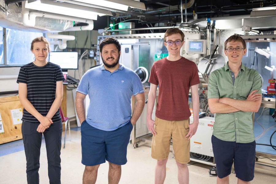 four people standing in a lab