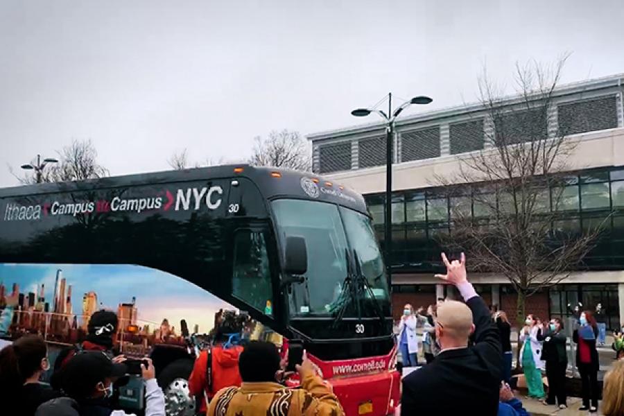 Bus driving past many people