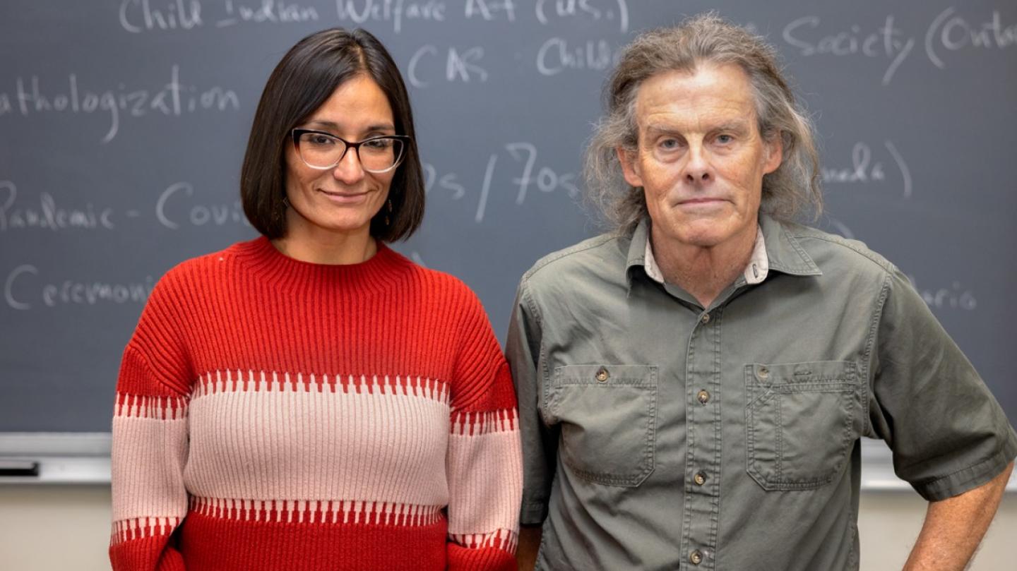 two people standing by blackboard