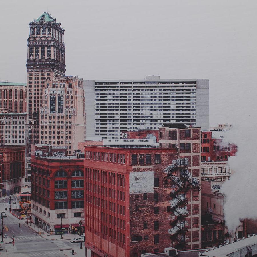 A cityscape with tall buildings and smoke coming from a building