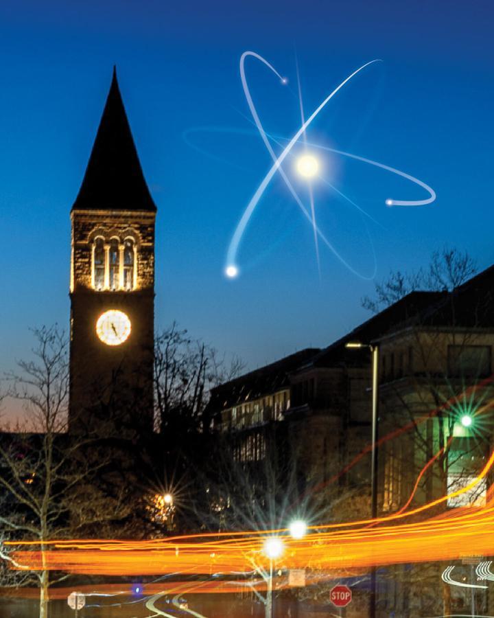 An artist's rendition of an atom in the sky next to McGraw Tower on Cornell's campus.