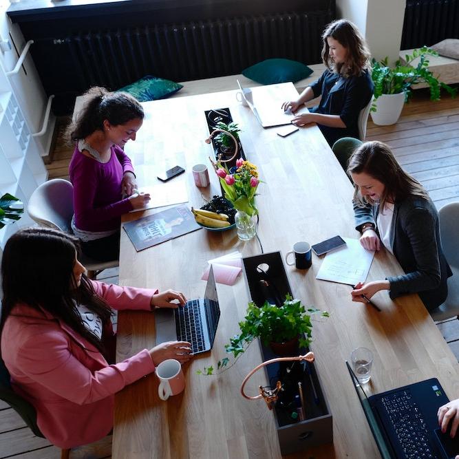 		Five people working on laptops at a long table
	