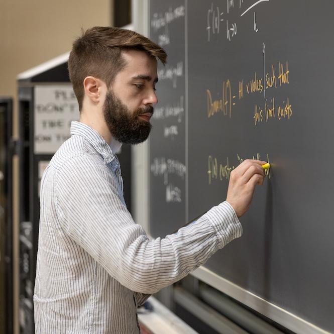 Person writing on a chalkboard