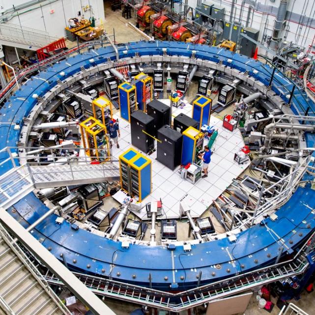 Looking down into a large scientific facility dominated by a blue ring the size of an auditorium