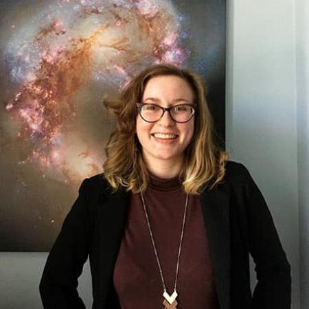 		Person standing in front of a poster showing outer space
	