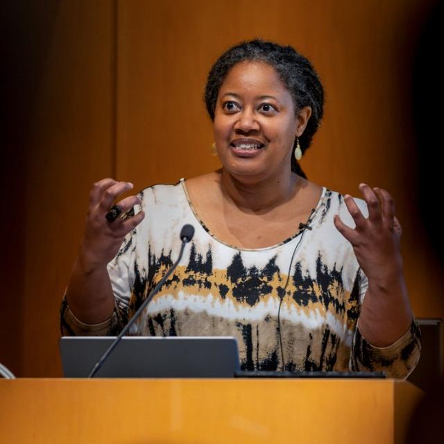 Person speaking at a podium gesturing with hands