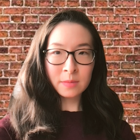 		Rhoda Feng, wearing big black glasses, long hair and a serious expression
	