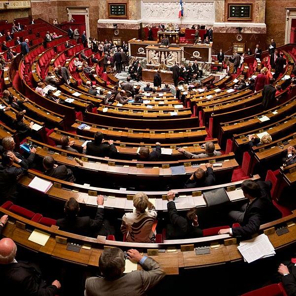 		Inside a legistative chamber, seats circling a central podium
	