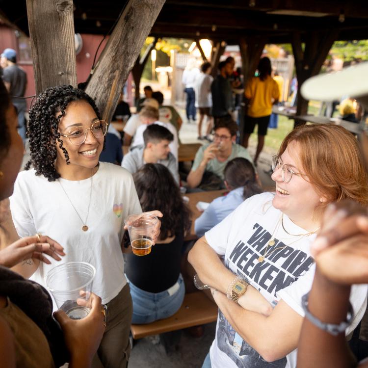 Four people stand in a circle, chatting and smiling