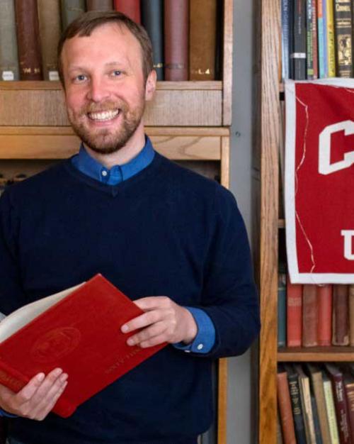 Person holding a book and smiling