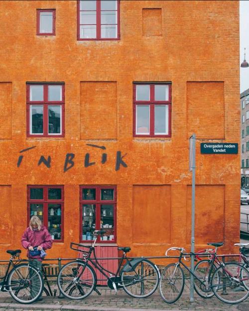 Orange building with bicycles parked in front