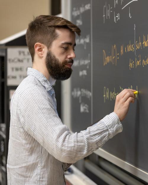 Person writing on a chalkboard