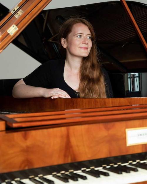 Person posing at a piano