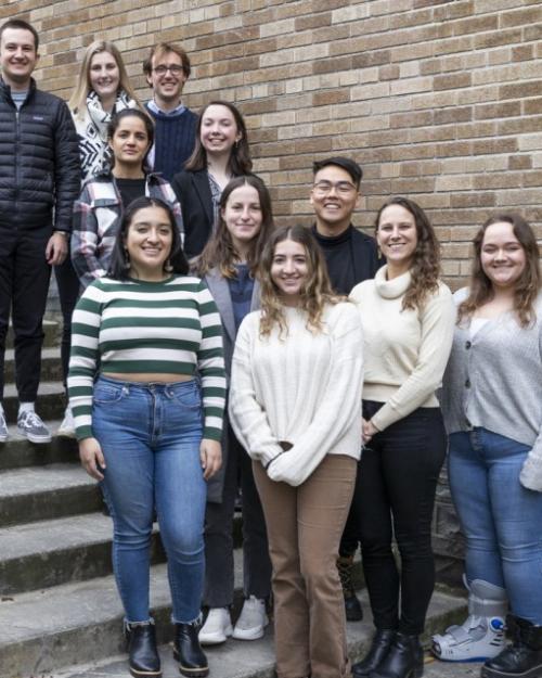 Eleven people pose on a staircase