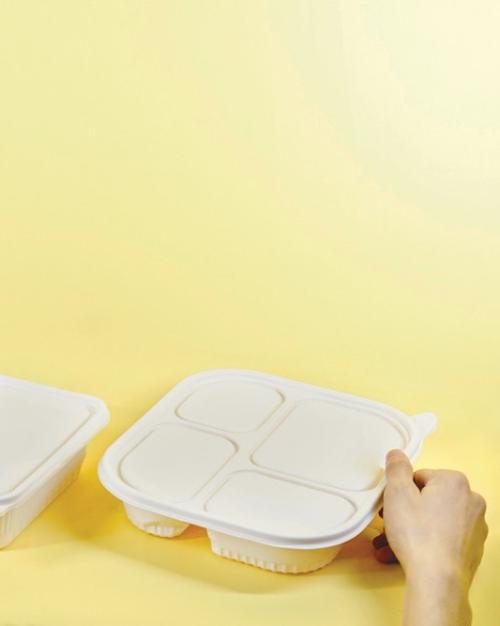 Three takeout food packages against a yellow background