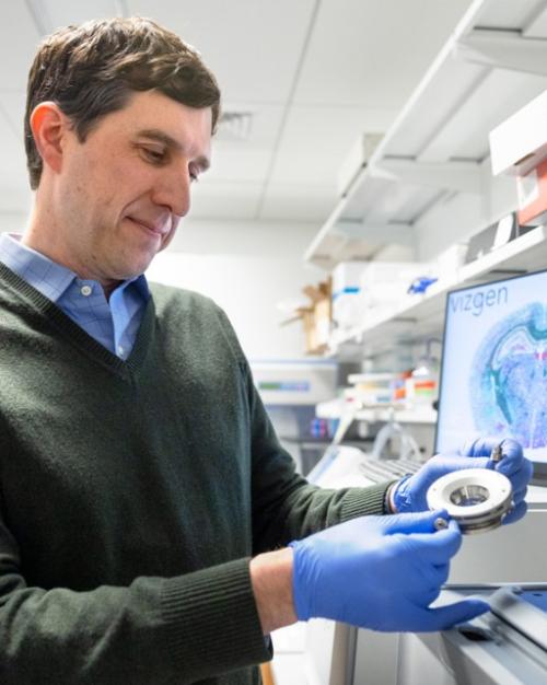 Person wearing blue gloves examines an instrument