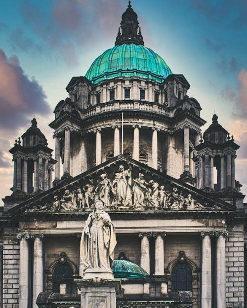 Stone building with a green dome and a sculpture in front