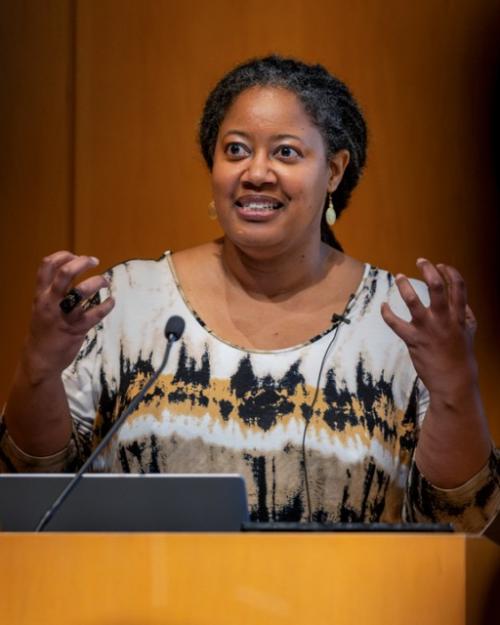 Person speaking at a podium gesturing with hands