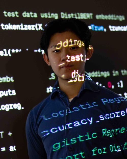 		student with text from projector shining on his face
	