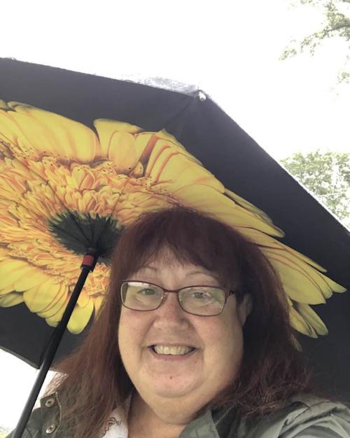 person with sunflower umbrella