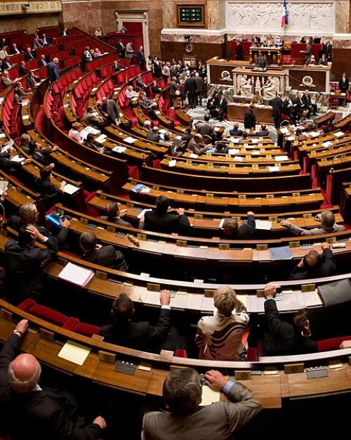 		Inside a legistative chamber, seats circling a central podium
	