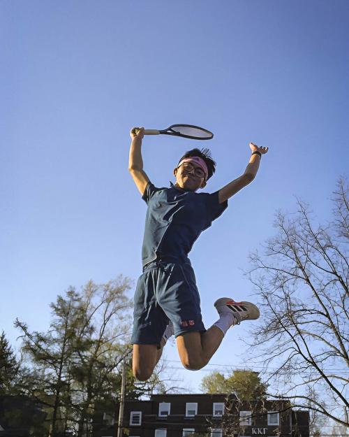 person jumping with tennis racket