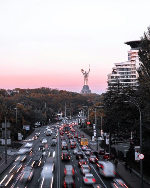 Cars speed down a six-lane road through a city