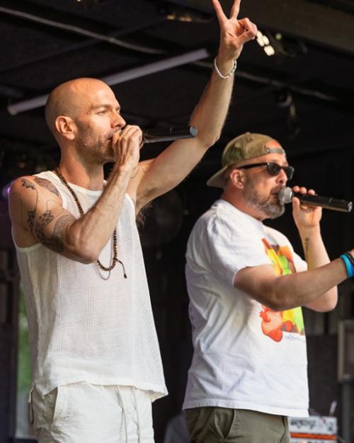 three people singing from a stage