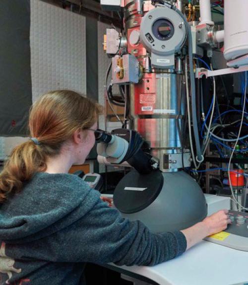  student working using large microscope for research