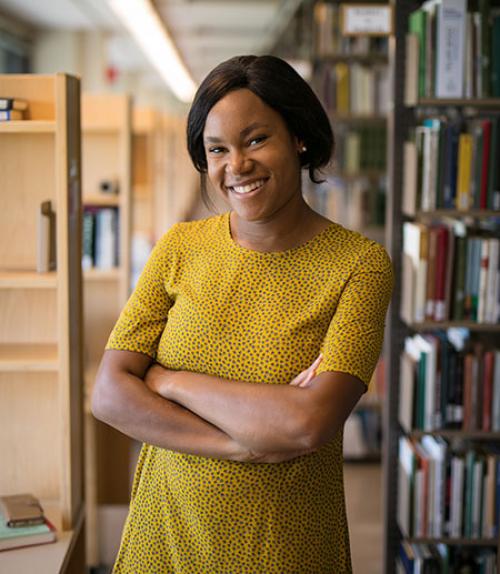  Abi Bernard standing amidst library shelves