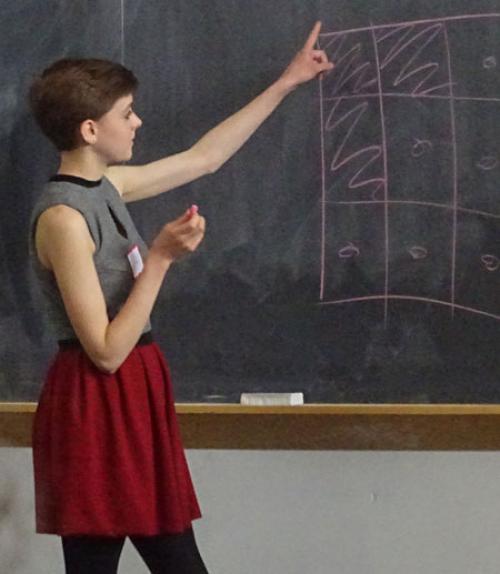  high school student giving presentation on chalkboard