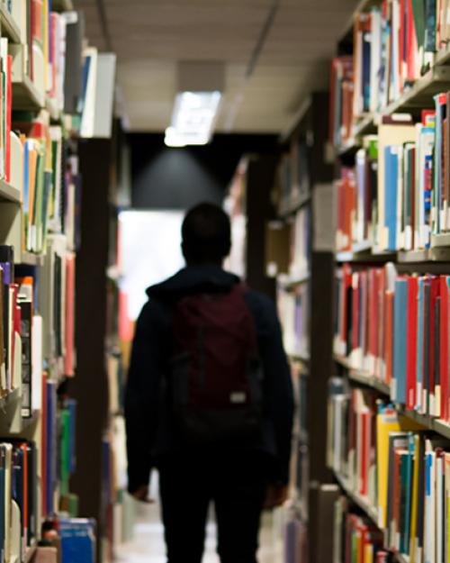  Figure shadowed by shelves of library books