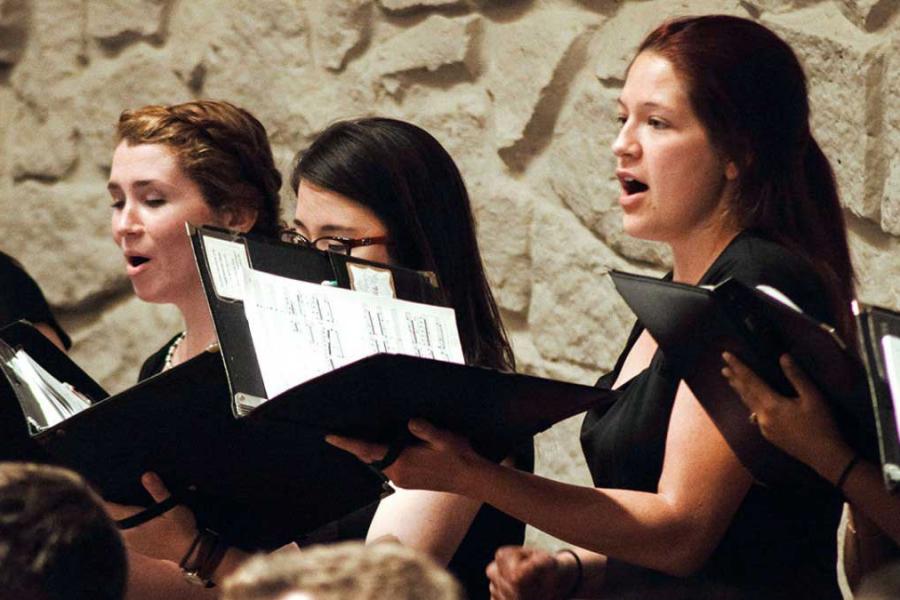 Three people sing in a choir