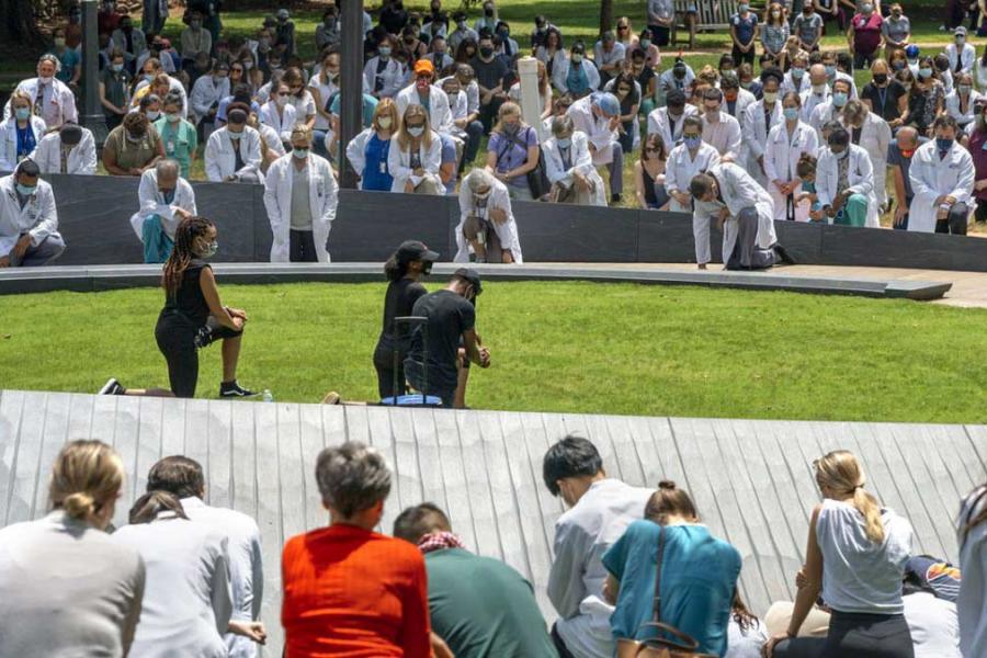 Many people kneeling at a memorial event